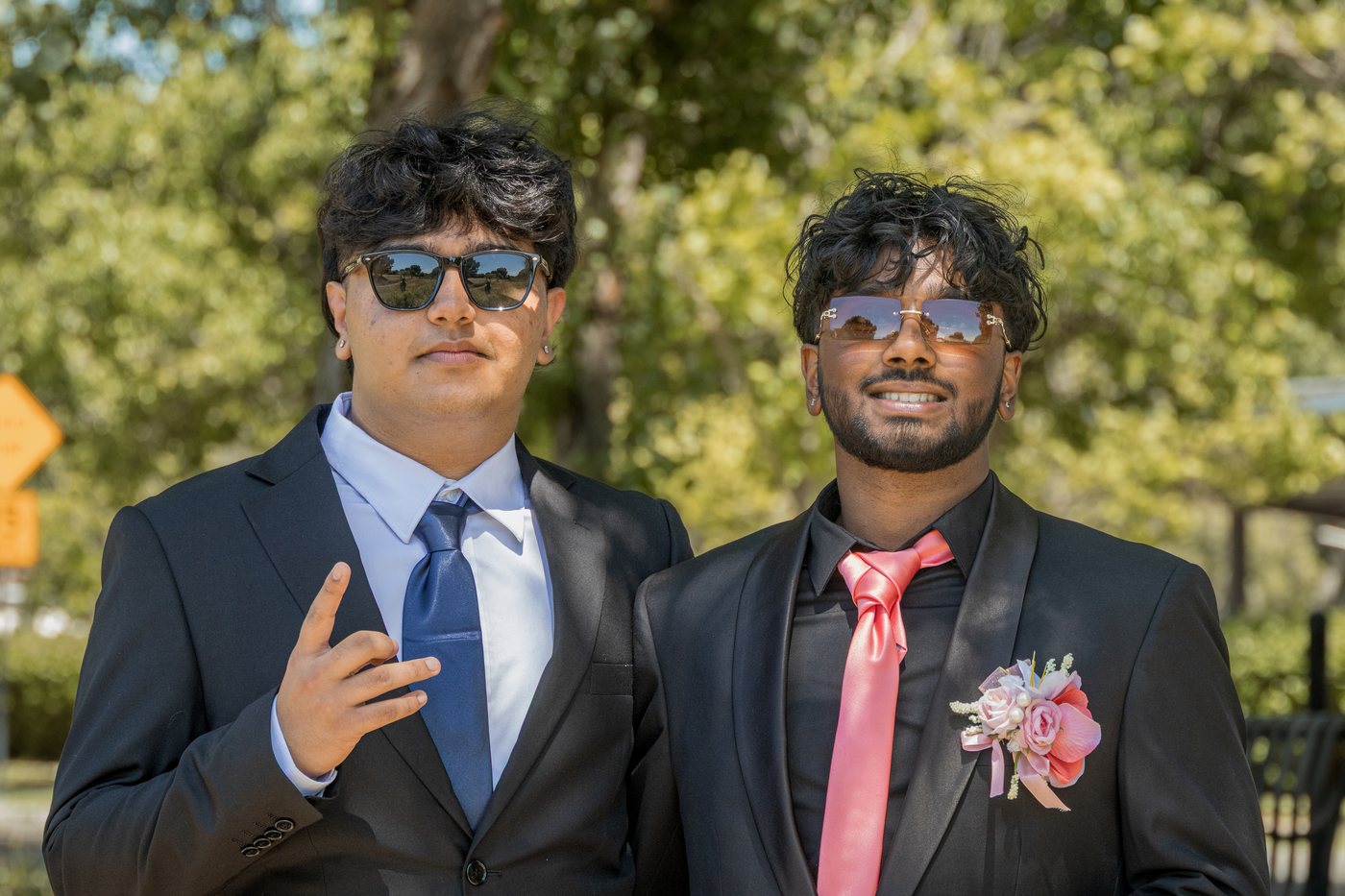 Two-guy prom portrait in black suits with blue and pink ties