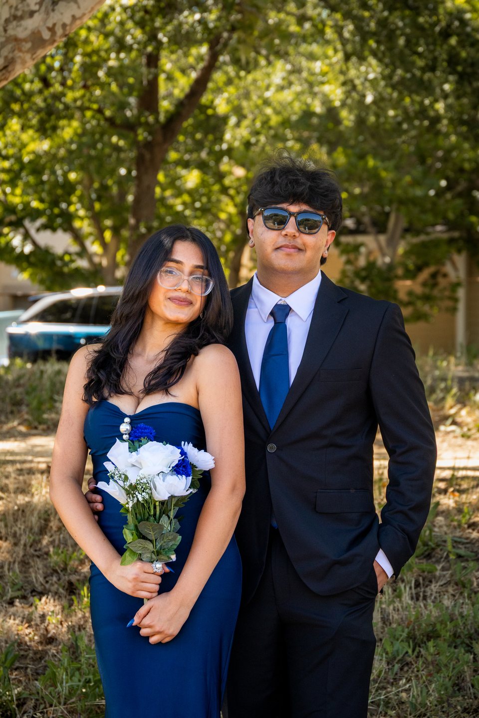 Formal prom couple portrait with blue dress and bouquet
