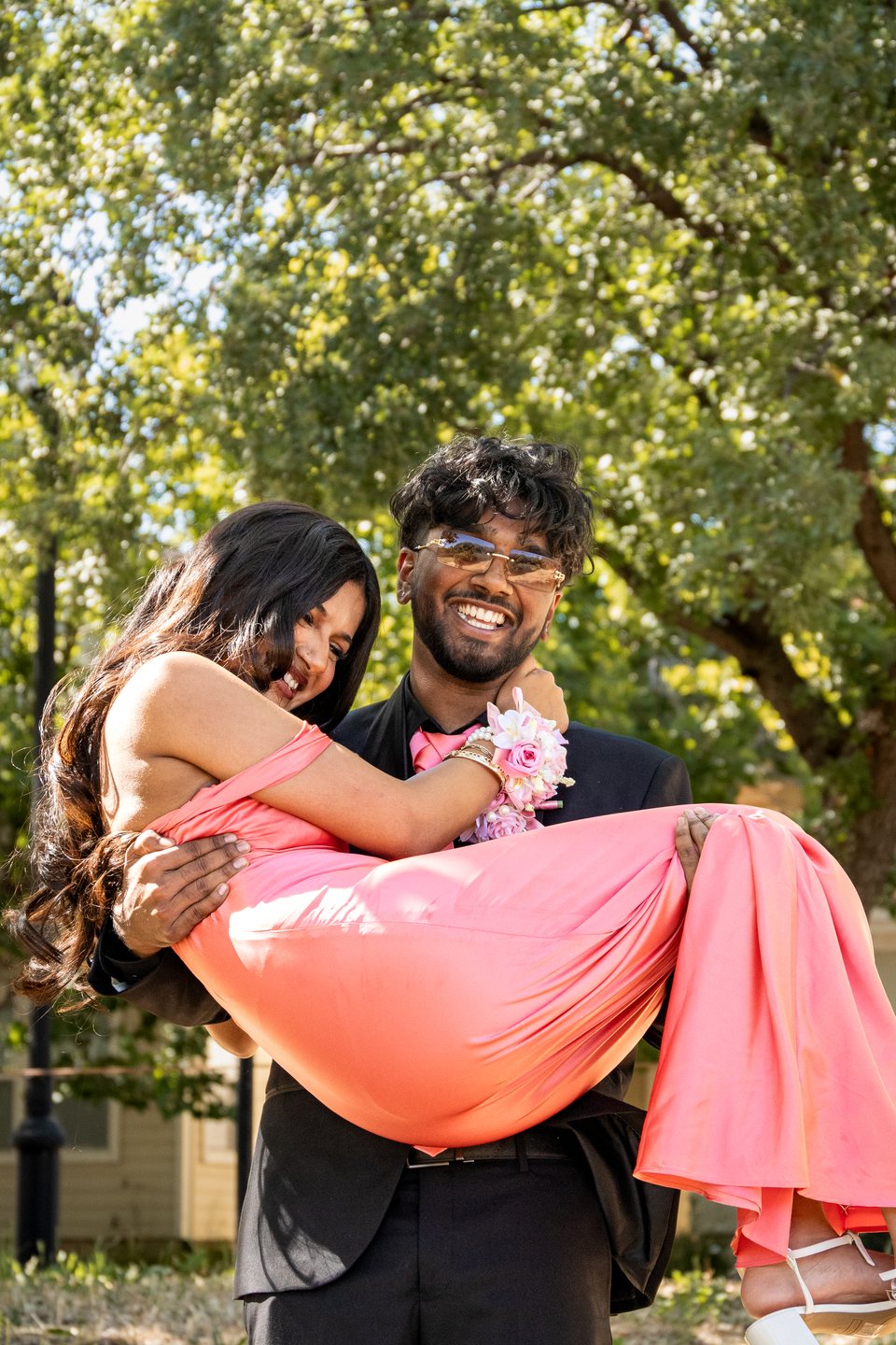 Candid pink dress lift prom portrait with laughing couple