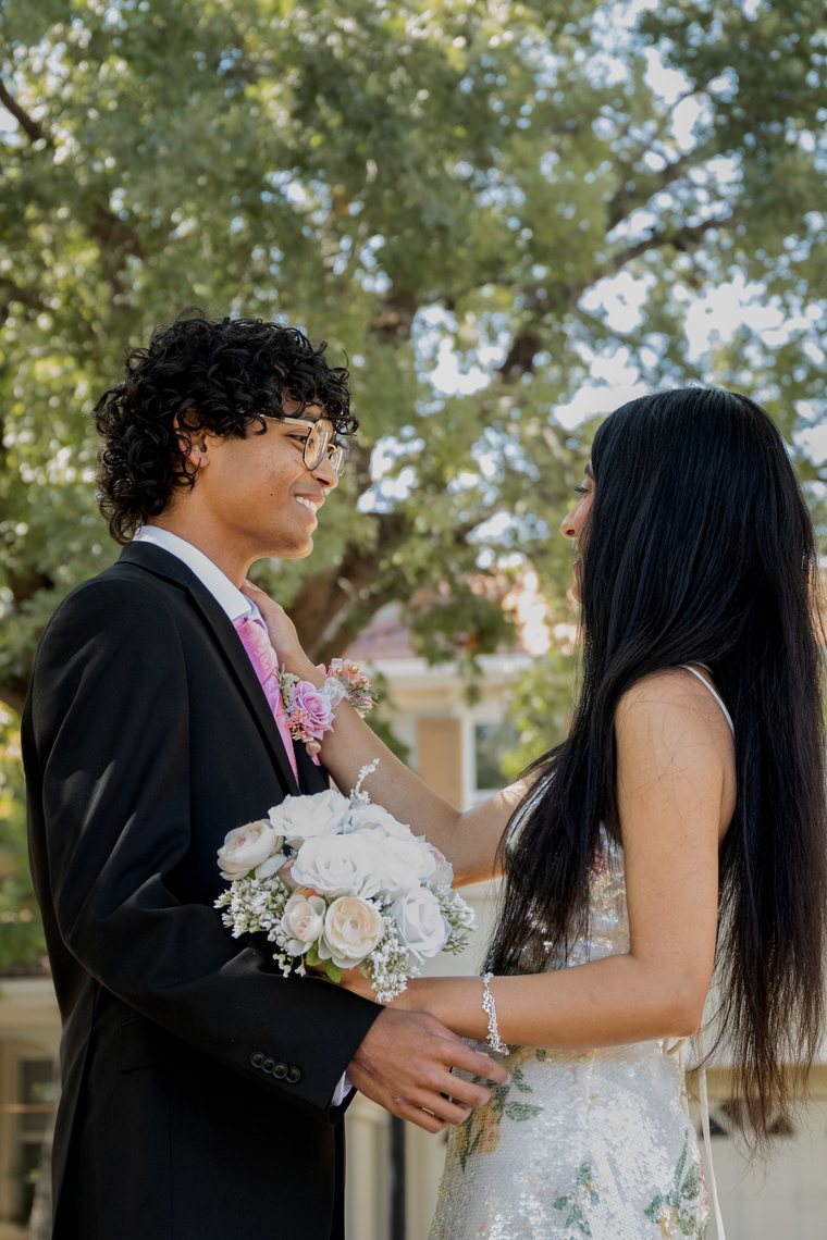 Close candid prom couple moment with white floral bouquet