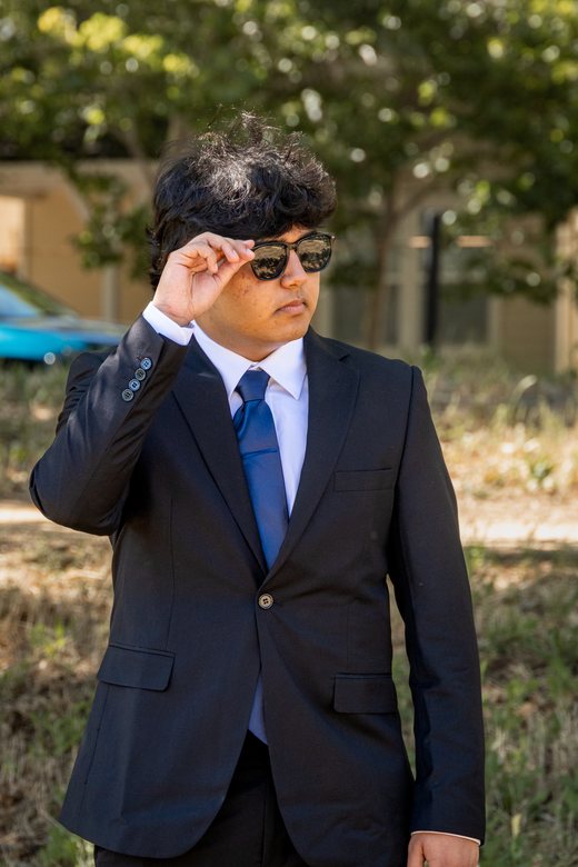 Solo prom portrait adjusting sunglasses
