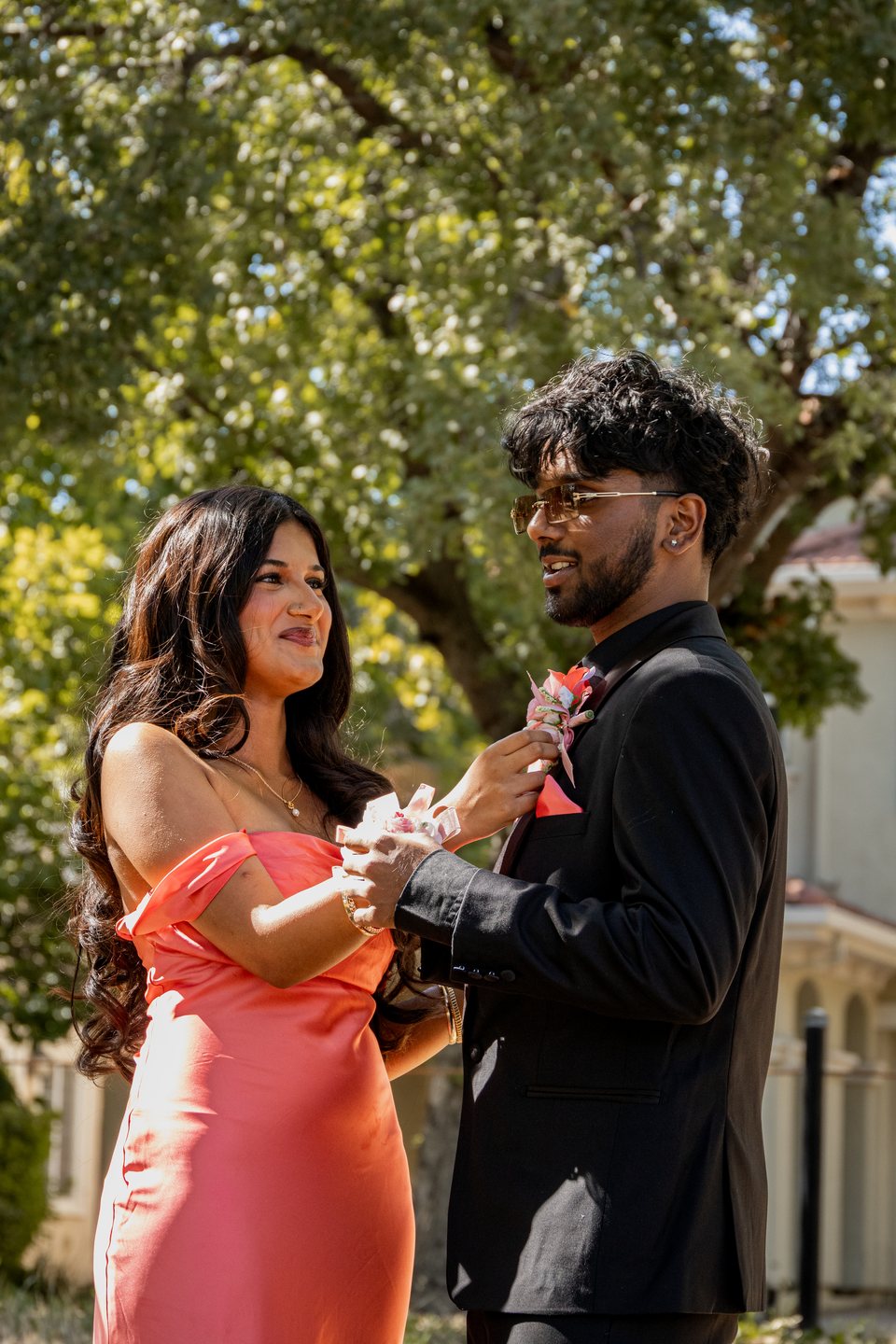 Prom couple sharing a boutonnière moment