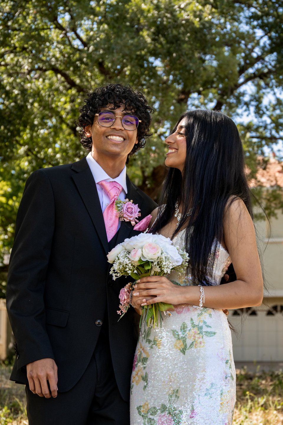 Candid prom couple portrait with floral bouquet